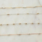 Three gold necklaces on a marble surface