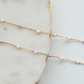 Gold chain necklace with pearls on a marble surface