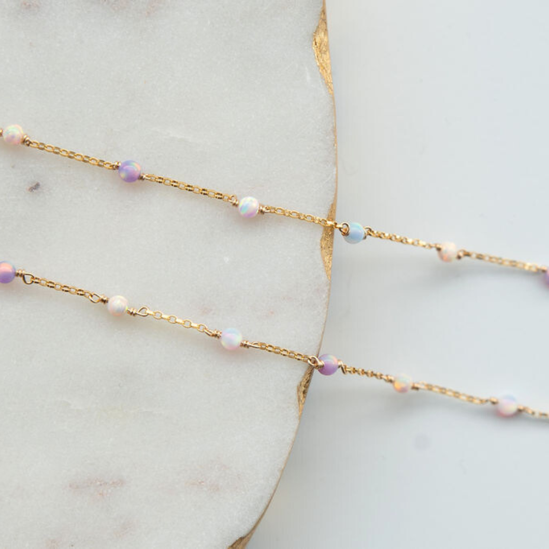 Gold chain necklace with pearls on a marble surface