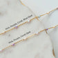 Two gold necklaces with pink, purple, and coral opal beads on a marble surface.