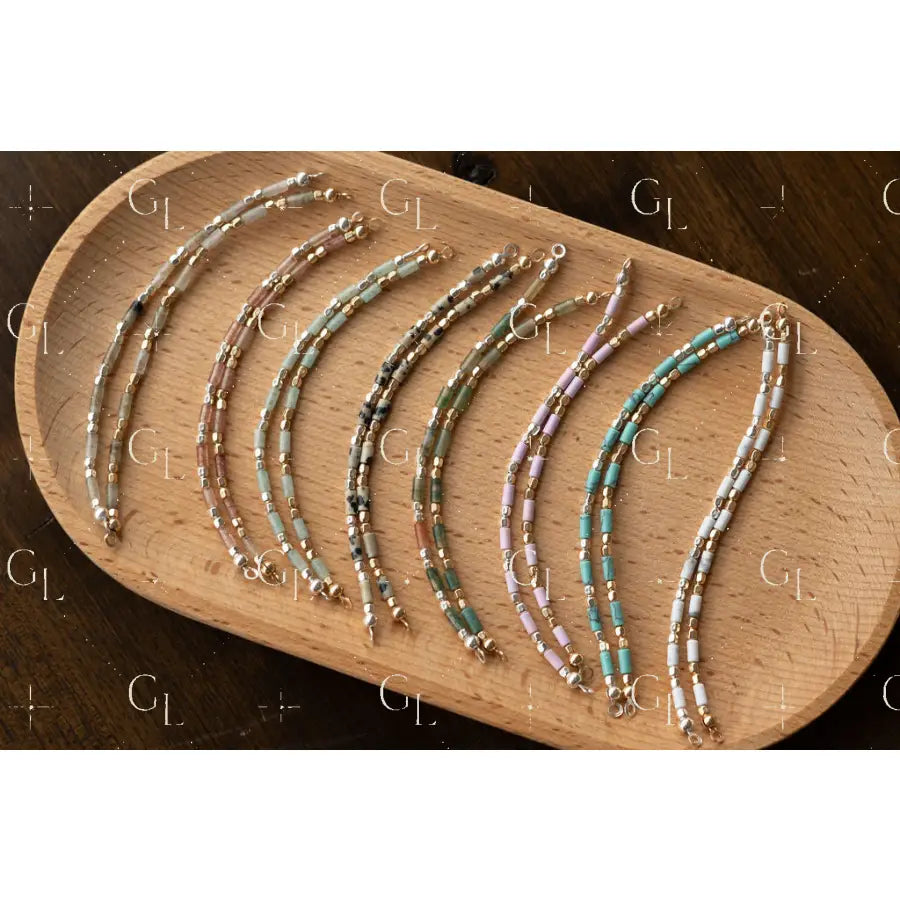 Set of beaded bracelets on a wooden tray