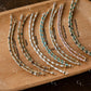 Set of beaded bracelet on a wooden board with labels
