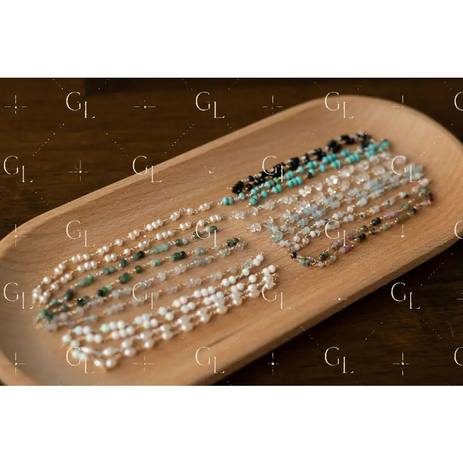 Three pearl bracelet on a wooden tray with a dark background