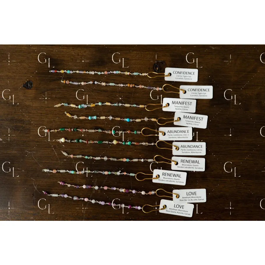 Set of beaded bracelets with corresponding labels on a wooden surface