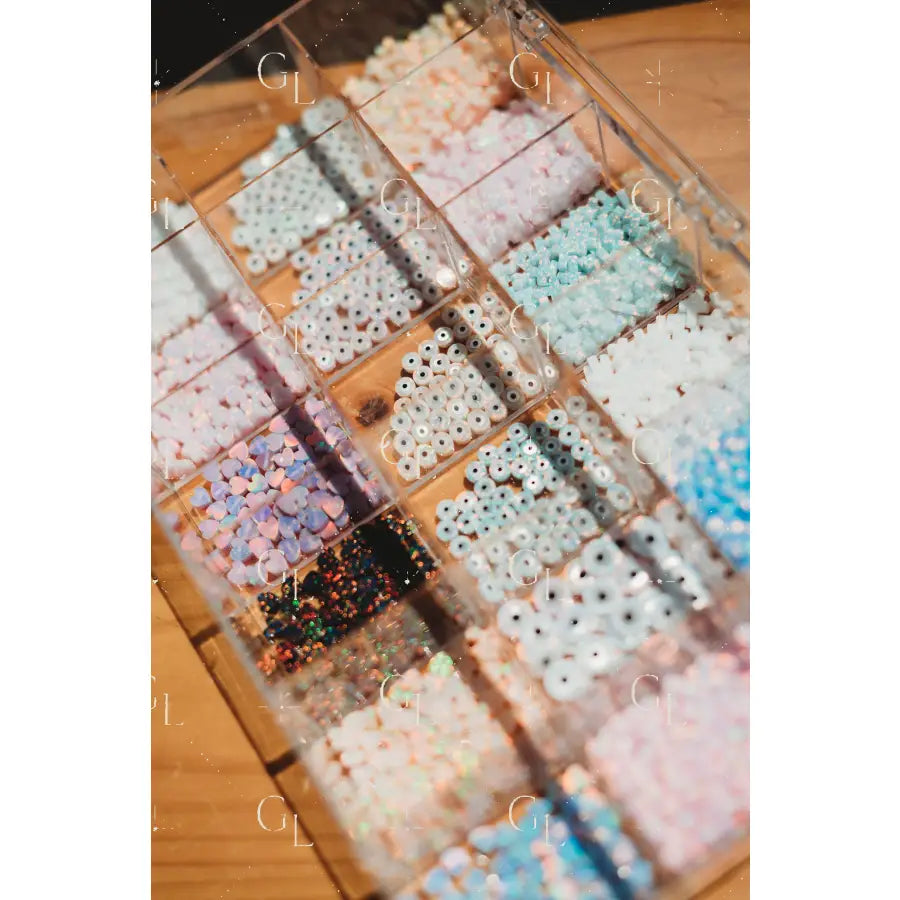 Assorted colorful beads in a clear container on a wooden surface