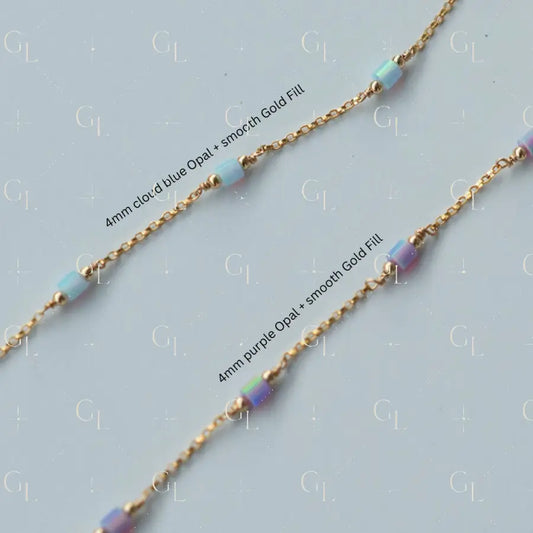 Gold chain necklace with cloud blue and purple opal beads on a light gray background