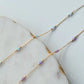 Gold chain necklace with small beads on a marble surface