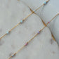 Gold chain necklace with small beads on a marble surface