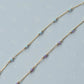 Gold  fill chain necklace with small beads on a light blue background