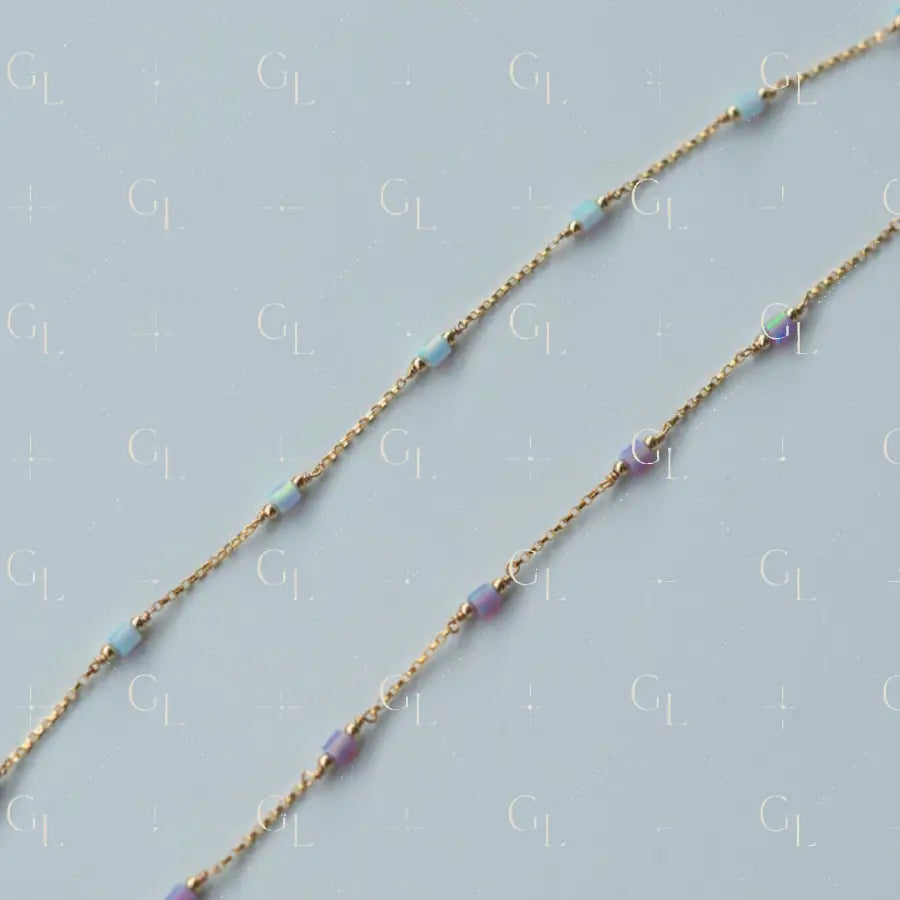 Gold  fill chain necklace with small beads on a light blue background