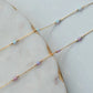 Gold chain necklace with small beads on a marble surface