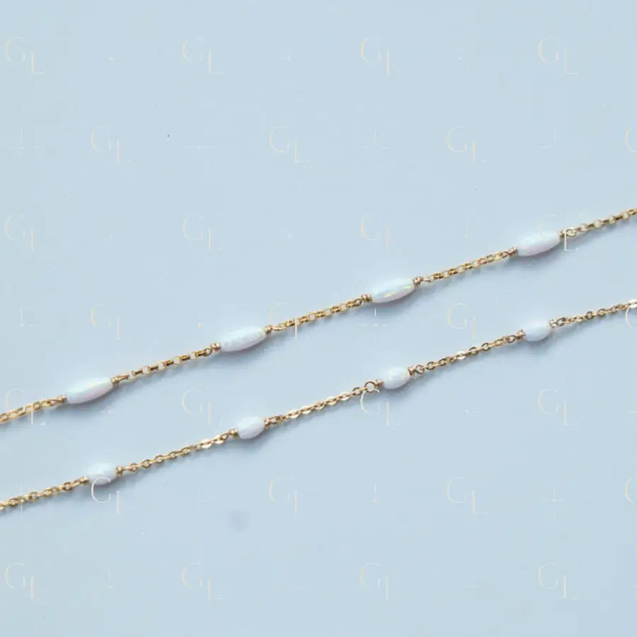 Gold chain with white beads on a light blue background