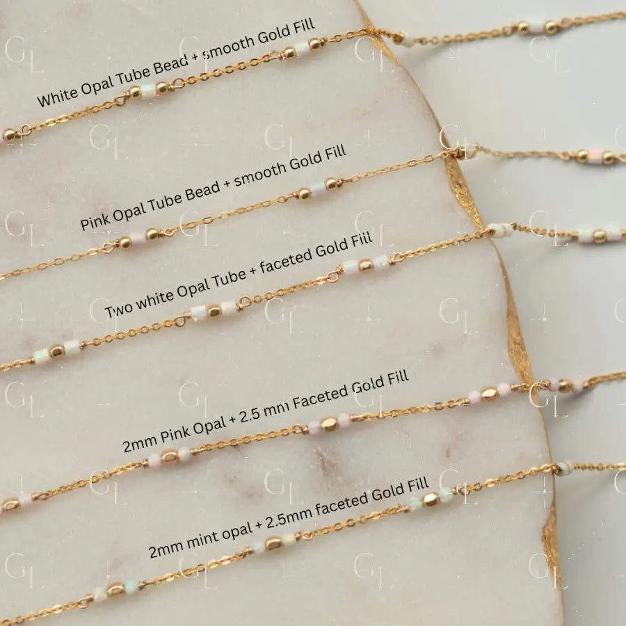 Gold fill necklaces with opal beads on a marble surface
