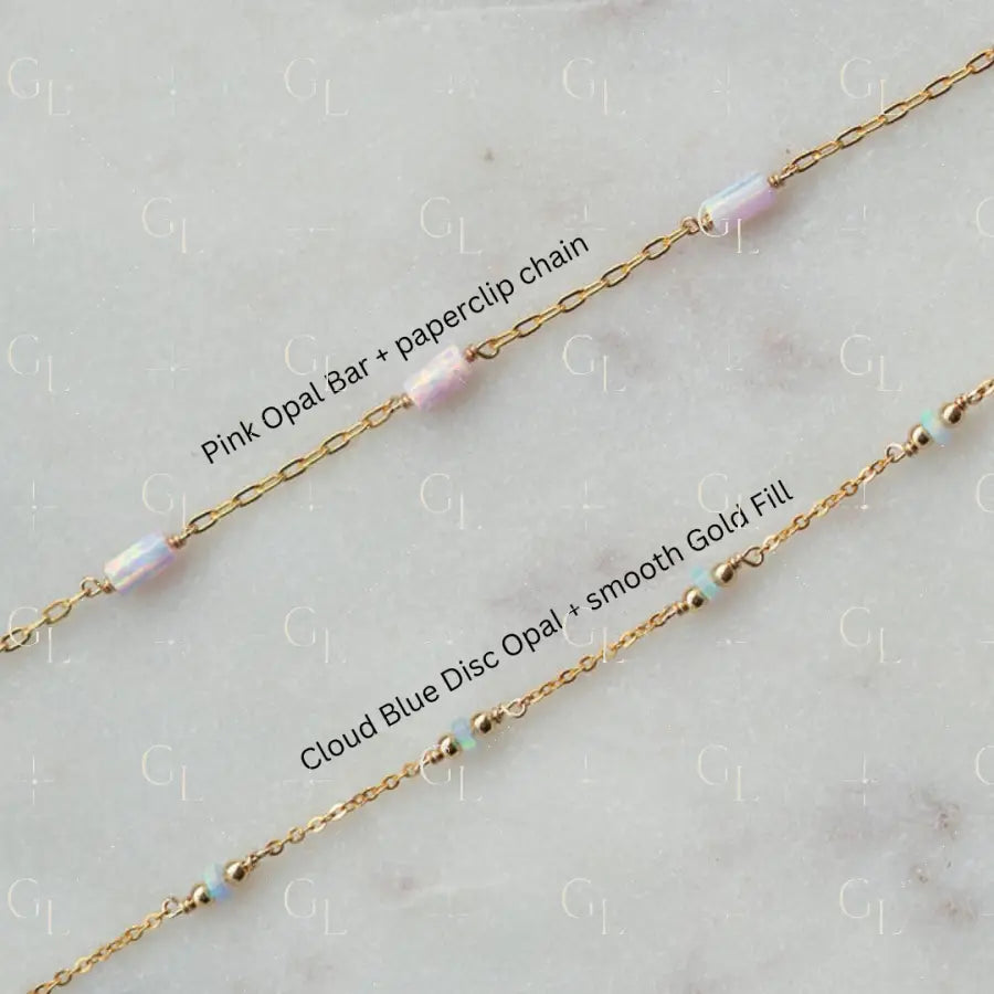 Gold chain with pink opal bar and cloud blue disc opal beads on a light gray background