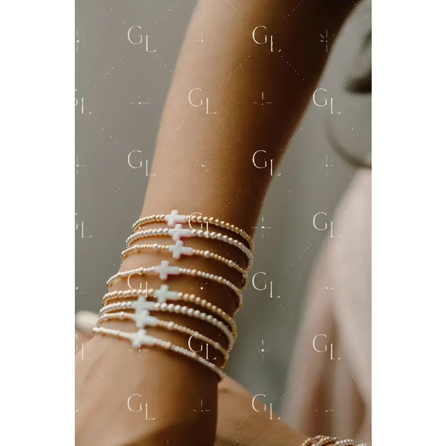 Close-up of a wrist wearing multiple pearl bracelets with a blurred background
