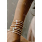 Close-up of a wrist wearing multiple pearl bracelets with a blurred background