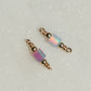 Two beaded charms with iridescent beads on a light gray background opal tube connectors!