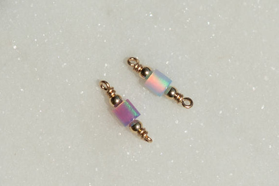 Two beaded charms with iridescent beads on a light gray background opal tube connectors!