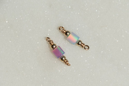 Two beaded charms with iridescent beads on a light gray background opal tube connectors!