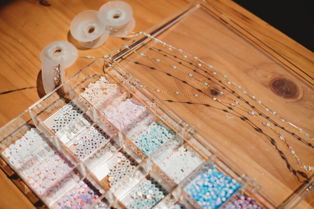 Jewelry display with beaded necklaces and a wooden box on a wooden surface