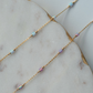 Gold chain necklace with small beads on a marble surface