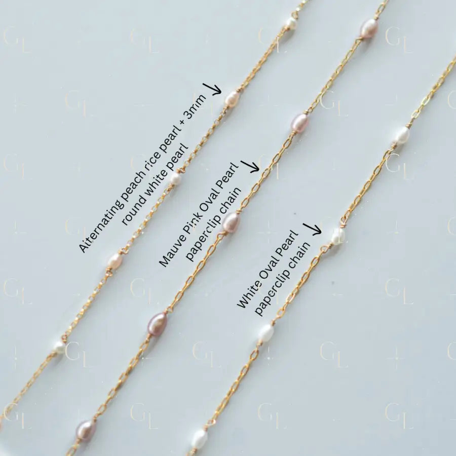 Three gold necklaces with pearl accents on a light gray background
