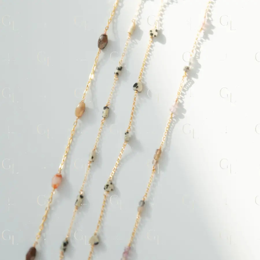 Layered necklace with beads on a light gray background