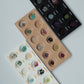 Three trays of gemstone samples on a light gray background
