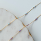 Gold chain necklace with small beads on a marble surface