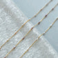 Gold chain necklace with small beads on a white towel