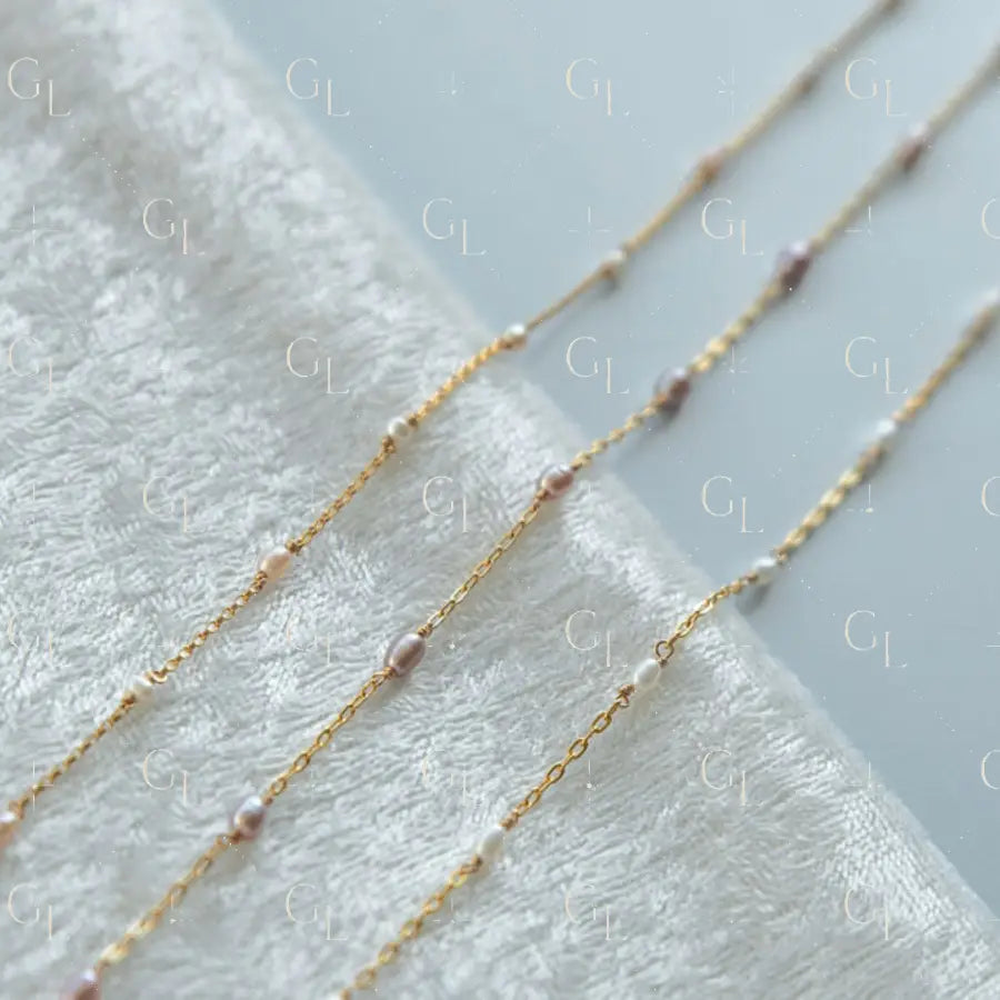 Gold chain necklace with small beads on a white towel
