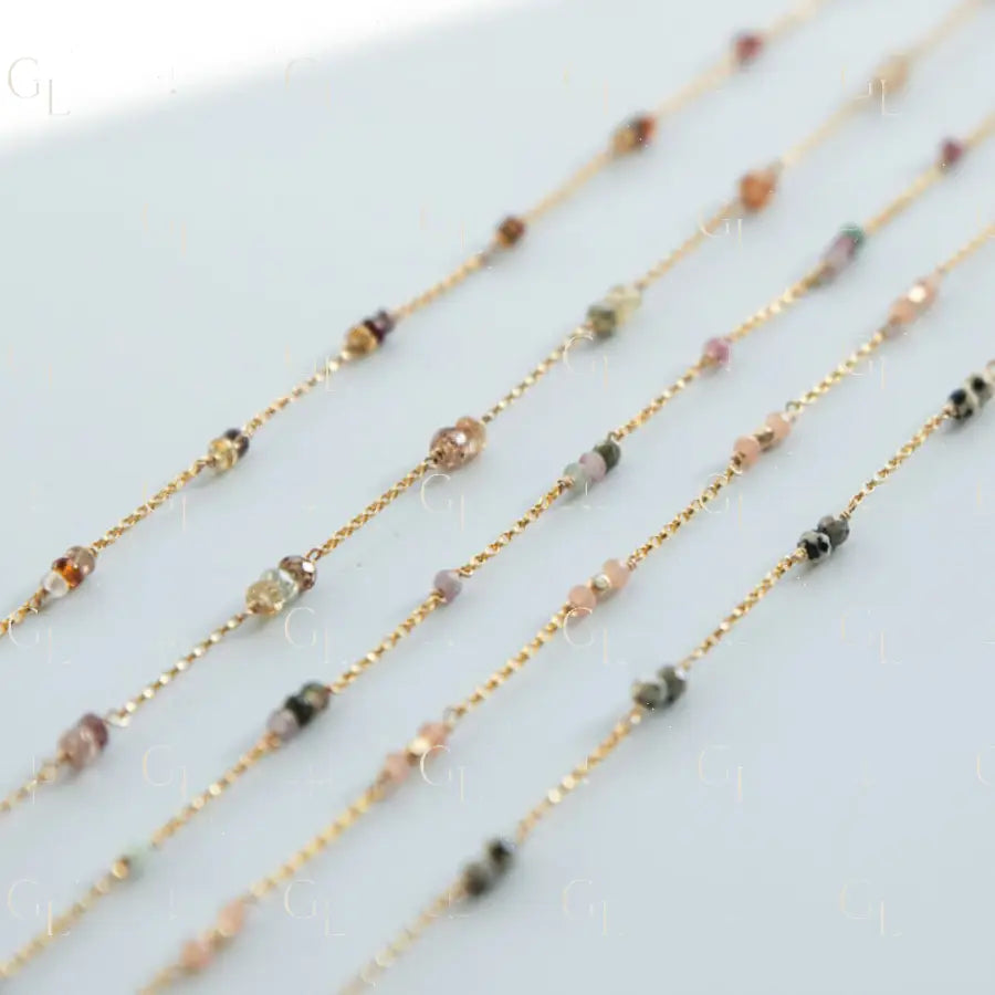 Gold chain necklaces with small beads on a light gray background