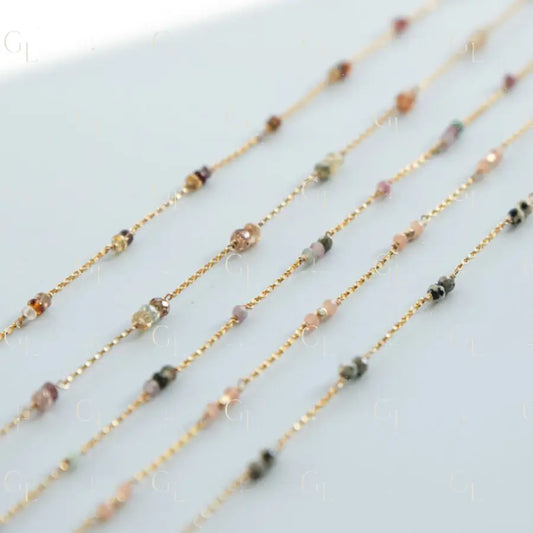Gold chain necklaces with small beads on a light gray background