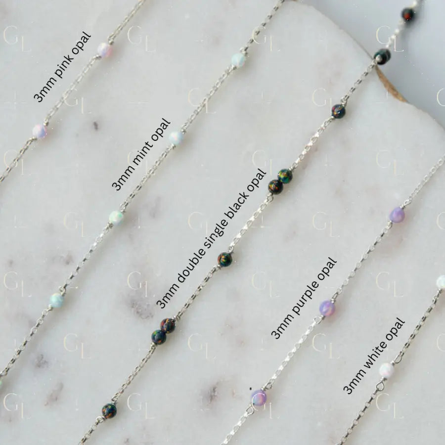 gold fill sterling silver chain with colored opal beads on a marble surface