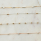Three gold necklaces on a marble surface