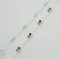 Necklace with multicolored beads on a light gray background