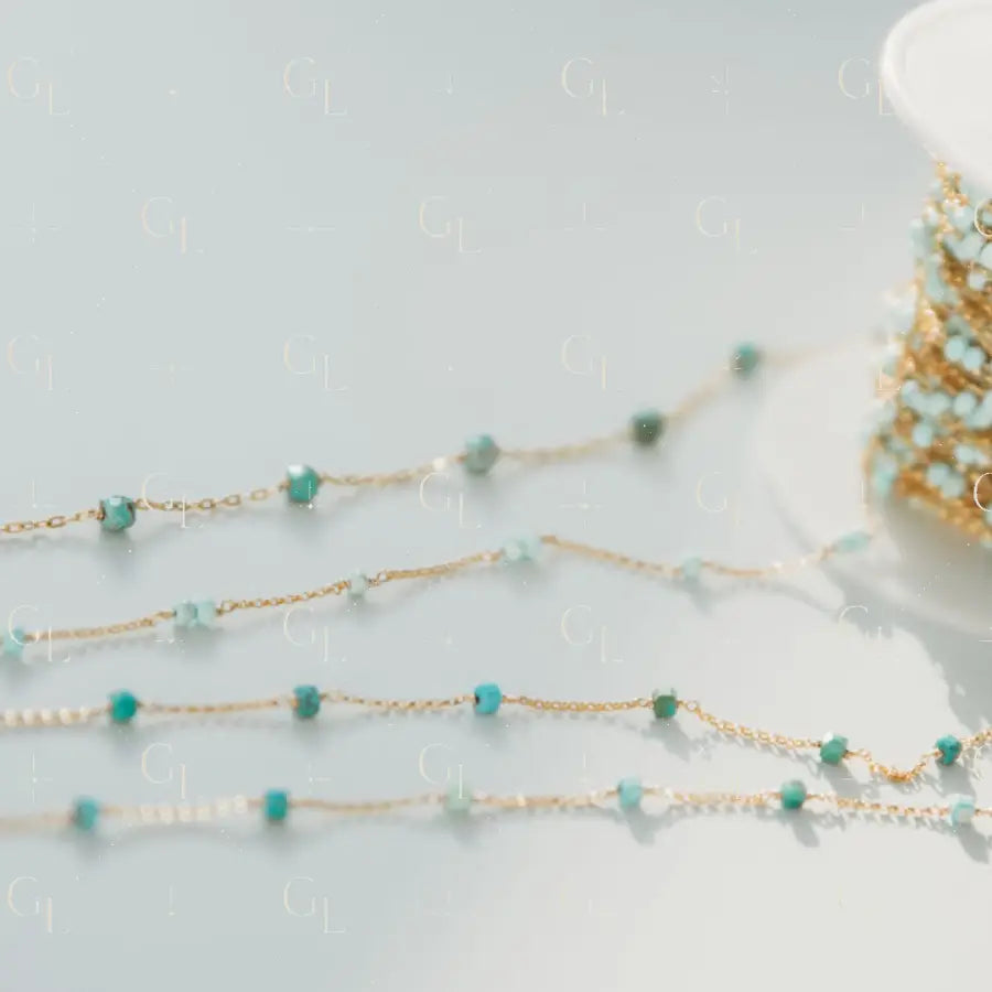 Gold chain with turquoise beads on a light gray background